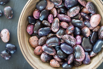 purple bean seeds of different colors on a black background. vegetarian raw food. food color background. bio food