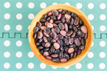 rain purple beans of different colors on a black background. vegetarian raw food. food color...