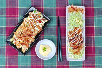 Grill flour wrap squid (as Takoyaki) served with Japan pizza (as Okonomiyaki) and side dish. 
