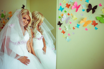 Bride smiles broad while posing behind a mirror