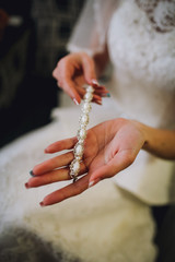 Beautiful young bride in a white dress. Last preparations for the wedding. The bride is waiting for the groom. Morning, the bride. Woman wearing jewelry. Looks in Mirror