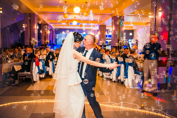 Wedding dance with  bubbles. Bride and groom whirl in restaurant. dancing couple