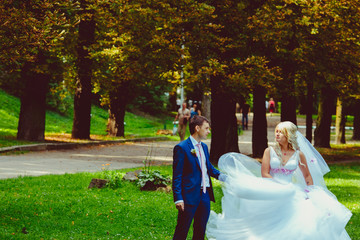 Magnificent blonde bride whirls before a groom while standing in