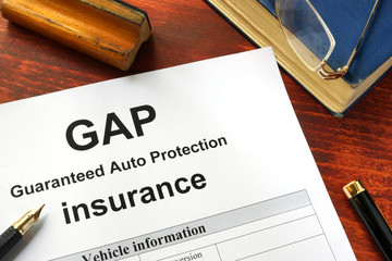 GAP insurance form on a table with a book.