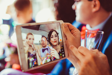 Man looks at a picture of bridesmaids on his iPad