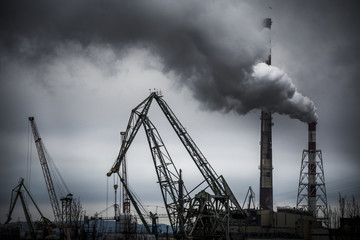 Shipyard on overcast day with smoke pumping from power plant