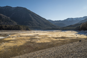 Menschen spazieren über den Seegrund am abgelassenen Stausee