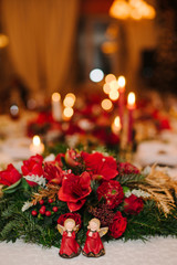 Fototapeta na wymiar table setting at winter wedding reception, wedding floral decoration, candles and angel statuettes