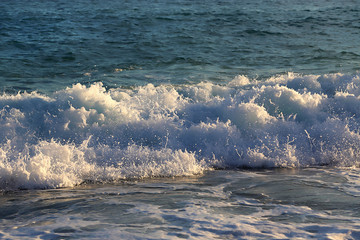 Sea waves and white foam on the evening coast