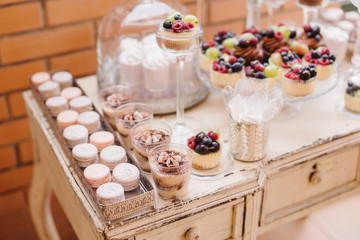 wedding candy bar with macaroni and cupcakes on the decorated vi