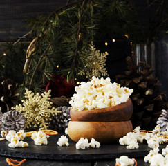 Obraz na płótnie Canvas popcorn in a wooden plate on the background of Christmas