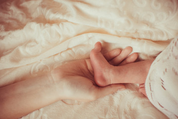 Mom's hand and baby's little foot