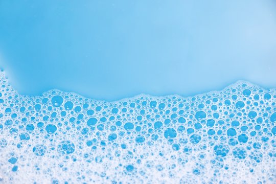 Abstract background of soap foam, suds, shower. Blue background. soft focus, macro view