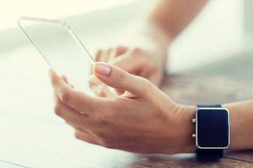 close up of hands with smart phone and watch