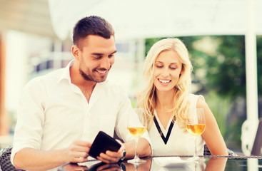 happy couple with wallet and bill at restaurant