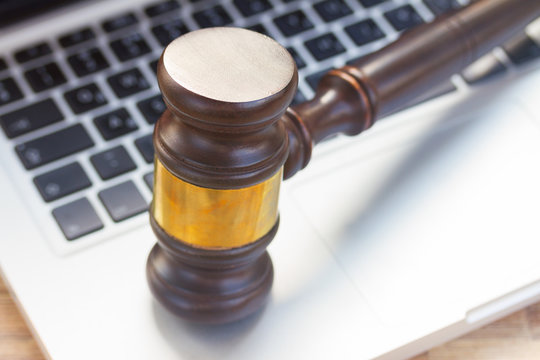 Wooden law gawel on laptop keyboard, judgement concept