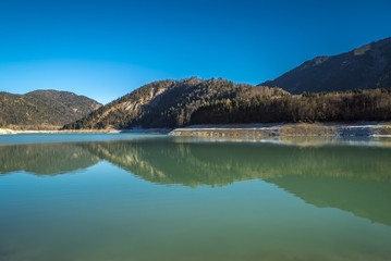 Spiegelung der winterlichen Berge im klaren Wasser des Sylvensteinsees