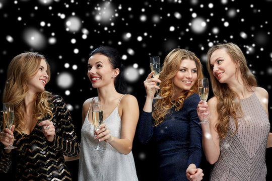 happy women with champagne glasses over snow