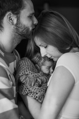 happy couple holding on  hands their  newborn baby