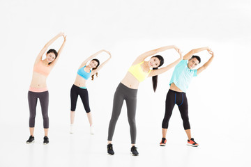 Fototapeta premium smiling young fit group stretching in gym