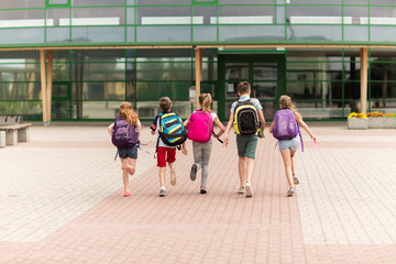 group of happy elementary school students running