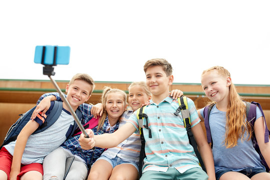 happy elementary school students taking selfie