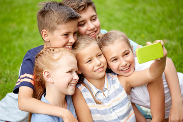 happy kids or friends taking selfie in summer park