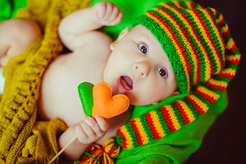 Little boy in a green hat lying in basket