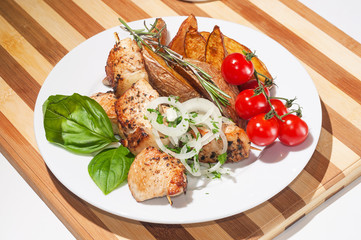 kebab with baked potatoes, cherry tomatoes and herbs