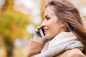 woman calling on smartphone in autumn park
