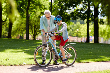 grandfather and boy with bicycle at summer park