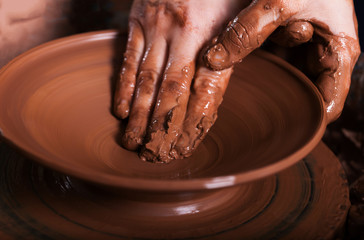 Potter shaping clay on the pottery wheel