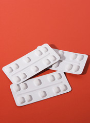 Pills on red background