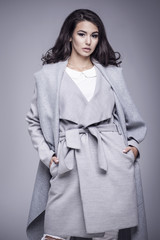 Beautiful young woman in an elegant gray coat