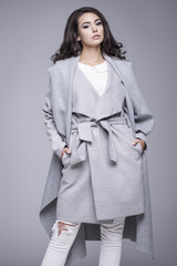 Beautiful young woman in an elegant gray coat
