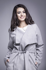 Beautiful young woman in an elegant gray coat