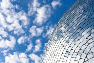 Blue sky and clouds reflecting on a building with mirrored glass
