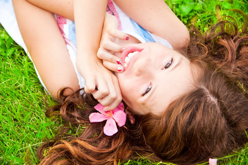 Obraz na płótnie Canvas Girl with long hair lying on grass