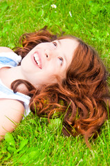 Girl with long hair lying on grass