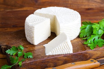 Soft salty cheese on a wooden table