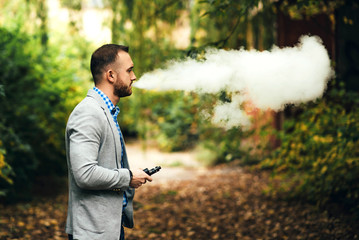 Men with beard smoking electronic cigarette outdoor