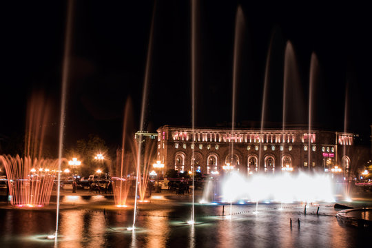 Musical fountain with colorful illumination at night with reflec