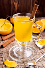 Citrus tea in glass mug with cinnamon stick.
