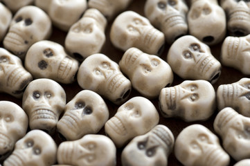 Background of a layer of white plastic toy skulls