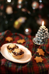 Fototapeta na wymiar Christmas pastry filled with apples, almonds and chocolate with star shaped cookies. Selective focus and festive background. 