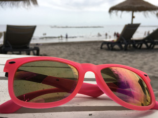 Pink sunglasses on the beach