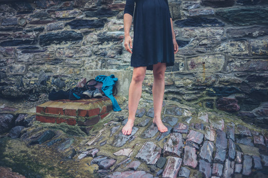 Young woman with bare legs standing on cobble stones
