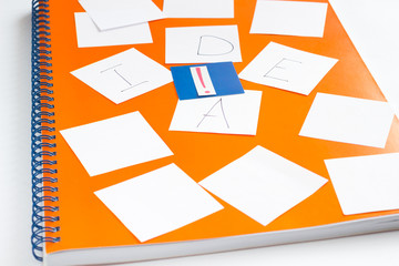 Orange notebook on a spring. Cards with letters 