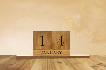 Cube shape calendar for January 14 on wooden surface with empty space for text.