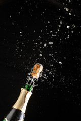 Closeup of champagne explosion. Vertical image on black background © Sergey Mironov
